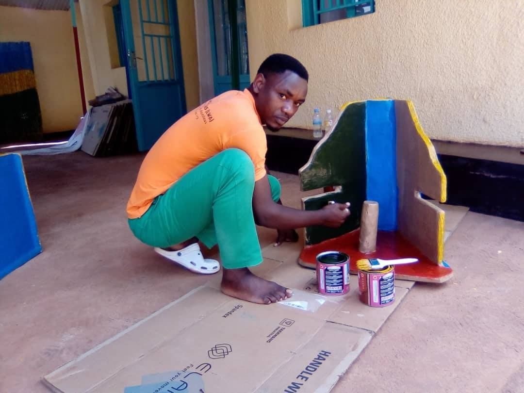 A craftsman painting a finished standing frame in the workshop yard