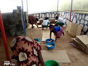 Women preparing and finishing panels in the workshop courtyard
